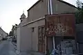 أحد ملاحق الحمّام إلى جانب لوحة إرشادية بهتت كتابتها.
