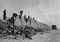 عمال يشرعون في هدم السور عام 1957.