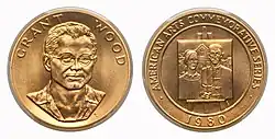 A gold medallion depicting a man and a painting