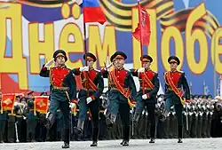 Honour guard marching with the علم روسيا and the راية النصر