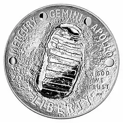 A coin with a footprint engraved in it, as well as the words "Mercury, Gemini, Apollo", "Liberty" and "In God We Trust"