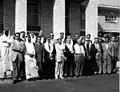 وفد برلماني سوري في زيارة لحقول أرامكو النفطية في السعودية عام 1956. الصف الأول من اليسار: نائب الزبداني ورئيس الحزب التعاوني الاشتراكي فيصل العسلي - وكيل وزارة الخارجية السعودي - رئيس المجلس السوري أكرم الحوراني - نائب اللاذقية عبد اللطيف يونس - نائب تلكلخ علي عبد الكريم الدندشي - سكرتير المجلس علي القدسي - النائب الاشتراكي فرزت المملوك - غير معروف - نائب حمص الدكتور عدنان الأتاسي - نائب اللاذقية جهاد الهواش - غير معروف. الصف الخلفي (من اليسار): مسؤول سعودي - النائب الإسلامي الدكتور مصطفى الزرقا - رئيس الوزراء الأسبق الدكتور معروف الدواليبي (باللباس العربي) - نائب حلب عن حزب الشعب أحمد قنبر - وزير الخارجية الأسبق ونائب حمص فيضي الأتاسي - رئيس المجلس بالوكالة ونائب دير الزور محمد بك العايش - غير معروف - وزير الخارجية الدكتور صلاح البيطار - غير معروف - نائب اللاذقية الشاعر نوفل إلياس.