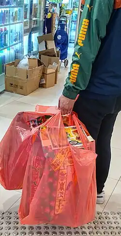 رجل يحمل أكياسًا من أوراق الجوس