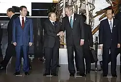 تبادل الرئيس جورج بوش والرئيس عبد العزيز بوتفليقة مصافحتهما في هوكايدو في 7 يوليو 2008. ومعهما الرئيس الروسي ديمتري ميدفيديف، إلى اليسار، ورئيس الوزراء الياباني ياسو فوكودا.