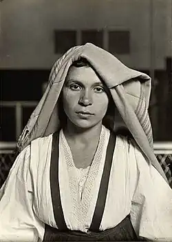 لويس ويكس هاين. امرأة بغطاء رأس مطوي، جزيرة إليس، نيويورك، 1905