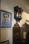 غرفة تحتوي على صورة لكفافيس بعد وفاته وصور لأصدقائه.