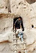 سلم خشبي يستعمله أطفال لصعود إلى مغارة.