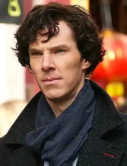 Thin, dark-haired young man in dark clothing