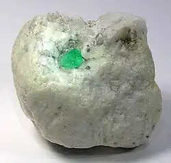 Emerald crystal (about 1&nbsp;cm) in كالسيت matrix, Muzo, Colombia.