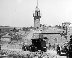 صورة للمدفعية البريطانية أثناء مرورها عبر القدس عام 1936. يظهر مسجد الشيخ جراح في الخلف.