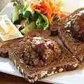 Broodje bal a slice of bread with a meatball and gravy, halved meatball served on slices of Dutch whole wheat bread.