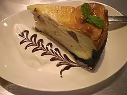 تشيز كيك مقدمة مع كريمة وصلصة شوكولاتة.