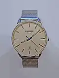 A watch with a fine stainless steel Milanese (dense and tight braided mesh variant) bracelet.