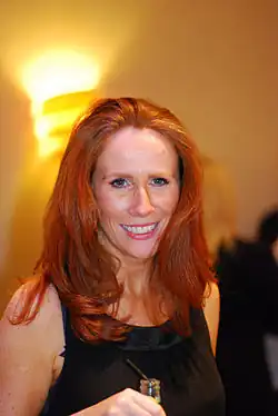 Tate smiling and holding a glass
