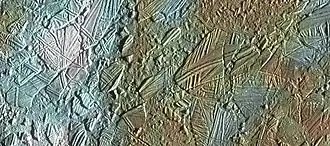 Enhanced-color view of part of Conamara Chaos, showing ice rafts up to 10 كـم (6 ميل) across. White areas are ejecta rays from the crater Pwyll.