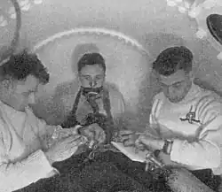 أجرت حكومة المملكة المتحدة في 1942-1943 اختبارات مكثفة حول سمية الأكسجين عند الغواصين؛ يصل ضغط الهواء في الحجرة إلى 3.7 بار، والشخص الموجود في الوسط يتنفس أكسجينًا تركيزه 100% من قناع التنفس.Donald, Part I 1947.