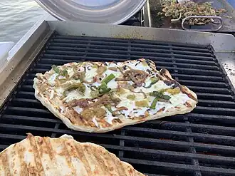شواء البيتزا في الهواء الطلق على سطح معدني