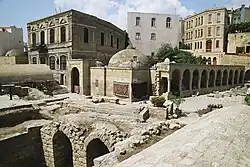 Ruins of underground buildings and a building with cuppola above ground.