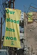 لافتات علم حزب الله مع شرح "بدمنا نفوز" بالقرب من الطيبة في جنوب لبنان في إشارة إلى حرب لبنان 2006