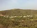قرية جبلية محاطة بالأشجار المزهرة والمنحدرات الخضراء
