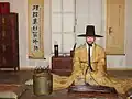 ذكر يرتدي اللباس الأرستقراطي. قات أي (قبعة من شعر الخيل) على رأسه و دوب أصفر أي (معطفا)