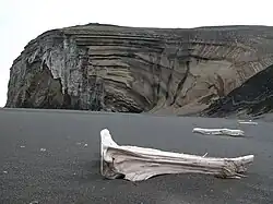 Egg-oeja, a peninsula on the coast of Jan Mayen. Sandy beach with a cliff in the background.