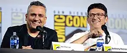 Joe and Anthony Russo speaking into microphones at Comic-Con in 2019