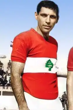 Joseph Abou Mrad wearing a red Lebanese jersey with a green cedar in the center inside a white horizontal band