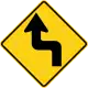 U.S. and Canada sharp reverse turns ahead sign.