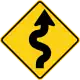 U.S. and Canada winding road ahead sign.