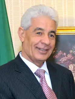 head shot of smiling, white-haired man in western business attire