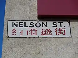 A sign reading Nelson Street, with text in Chinese underneath.