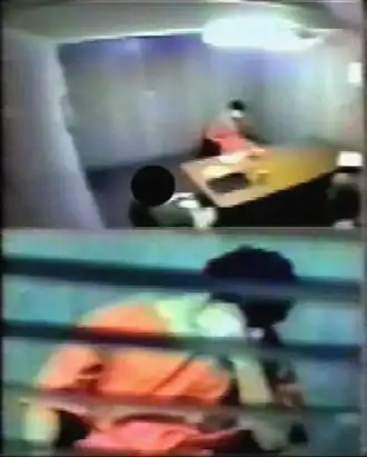 المععتقل الكندي عمر خضر أثناء عرضه على اللجان العسكرية مرتديًا الزي البرتقالي.