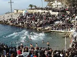 احتغالات عيد الغطاس في اليونان، في العيد يُلقى صليب في البحر ويقوم شاب بالغوص لاسترجاعه والغطس في بِرك المياه المتجمدة.
