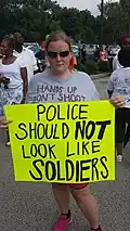 A person protesting against the militarization of police, August 17