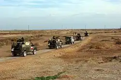 A convoy for the Polish CIMIC group (Civilian Military Cooperation) heads to an elementary school in Ad Diwaniyah, Iraq on January 19, 2005. They are going to deliver school supplies and toys.