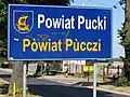 Bilingual sign in Polish and Kashubian in Pogórze, Puck County, Poland, on road from غدينيا to Rewa