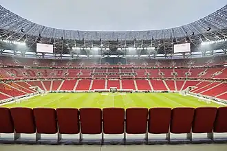 Photograph of a modern football stadium's interior; the stands are full of spectators