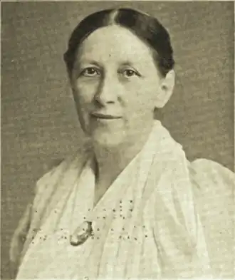 19th-century B&W portrait photo of a woman with her hair in an updo, wearing a white blouse.