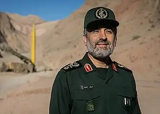 العميد أمير علي حاجي زاده قائد القوة الجوفضائية لحرس الثورة الإسلامية إلی جانب صاروخ قدر H في مناورات اقتدار الولاية.