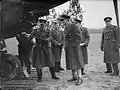 Royal Air Force officers wearing greatcoats, inspecting an aircraft in France