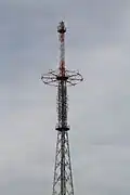 Sendeturmspitze mit rotem Ringausleger und acht vertikalen Reusenseilen