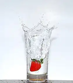 a glass of transparent water sitting on a wooden table