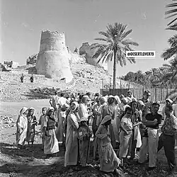 سياح يقفون لالتقاط صورة مع المحليين أمام القلعة. خمسينيات القرن العشرين.