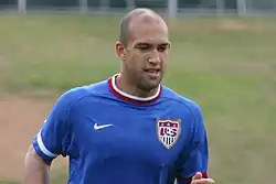 Top half of a male athlete who appears to be running