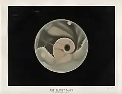 An orange and gray disk centered on a black background, roughly showing various light and dark features. The upper half is generally darker than the bottom.