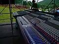 جهاز خلط Yamaha PM4000 وMidas Heritage 3000 في مقدمة الحفل الموسيقي في الهواء الطلق.