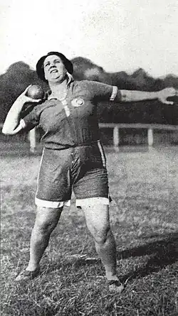Violette Morris, un poids dans la main, prend de l’élan avant de lancer.