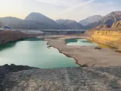 الوادي مع جبال الحجر الشمالية الغربية في الخلفية. لاحظ أن جبل جيس ، أعلى جبل في الإمارات العربية المتحدة، قريب..