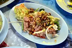 يم نعيم، سلطة مع نقانق نعيم مصنوعة من لحم الخنزير النيء المخمر مع الأرز الدبق.